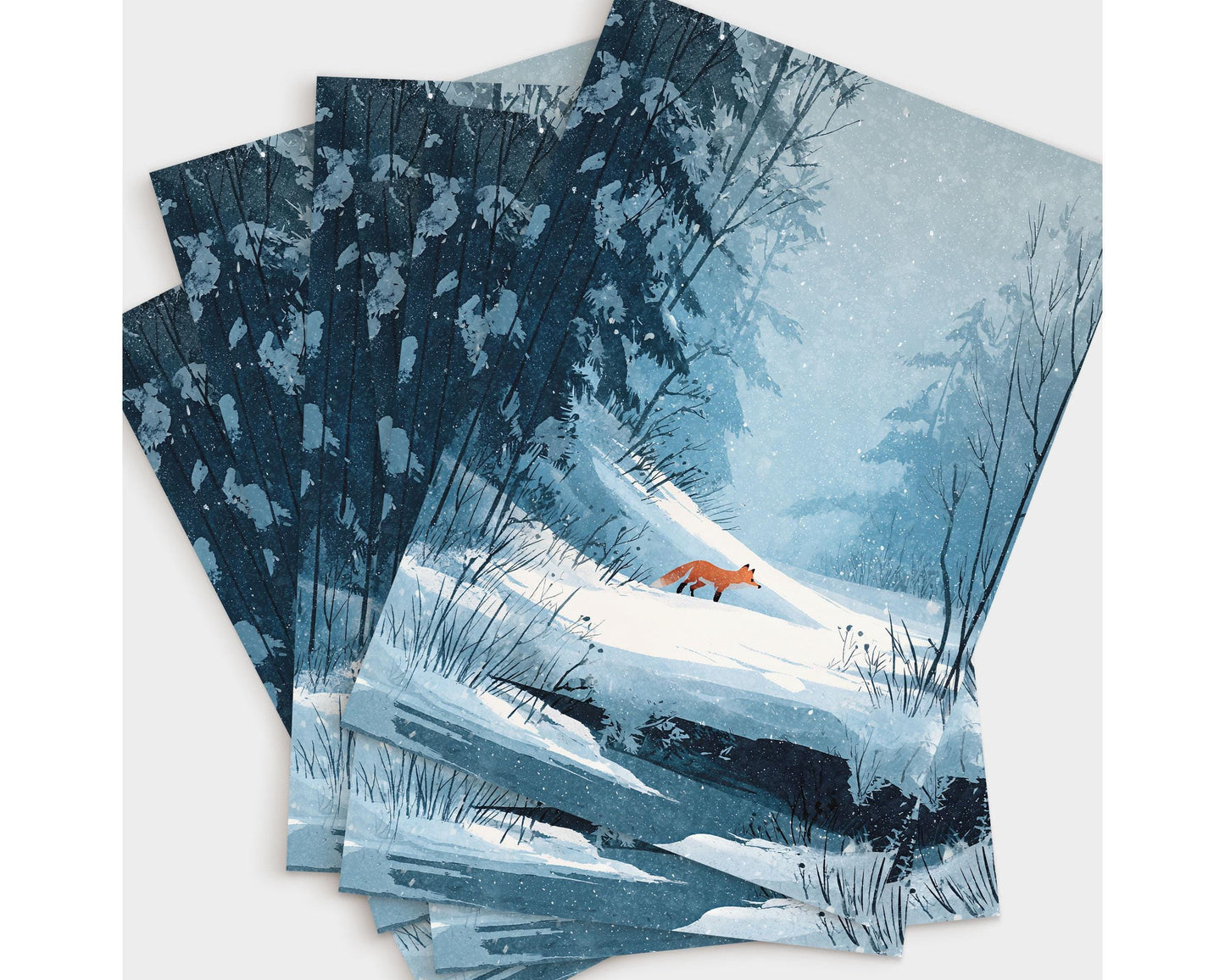 Set of greeting cards featuring a winter illustration of a red fox walking through a snowy forest. The design shows soft blue and white tones with snow-covered trees, bare branches, and gentle snowfall, creating a serene, woodland atmosphere perfect for winter or holiday correspondence.