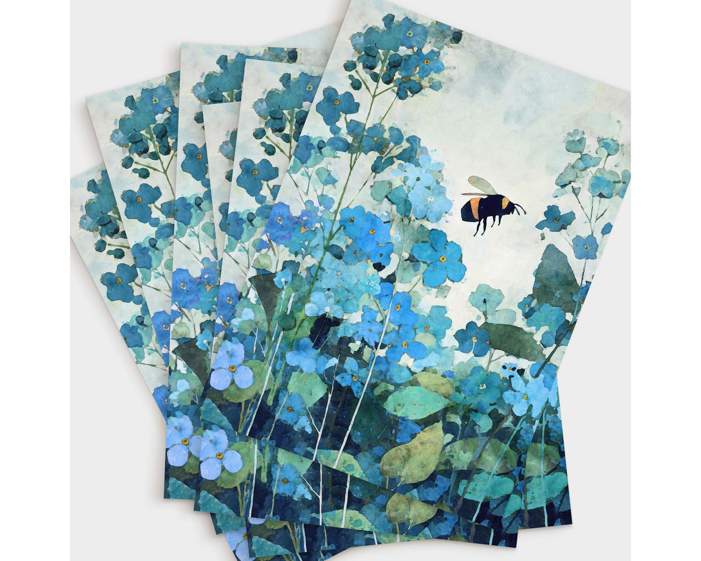 Set of watercolor-style note cards featuring a bumblebee hovering among blue forget-me-not flowers, with layered teal and green foliage. Multiple prints are fanned out, highlighting the botanical design in soft, cool blue tones.