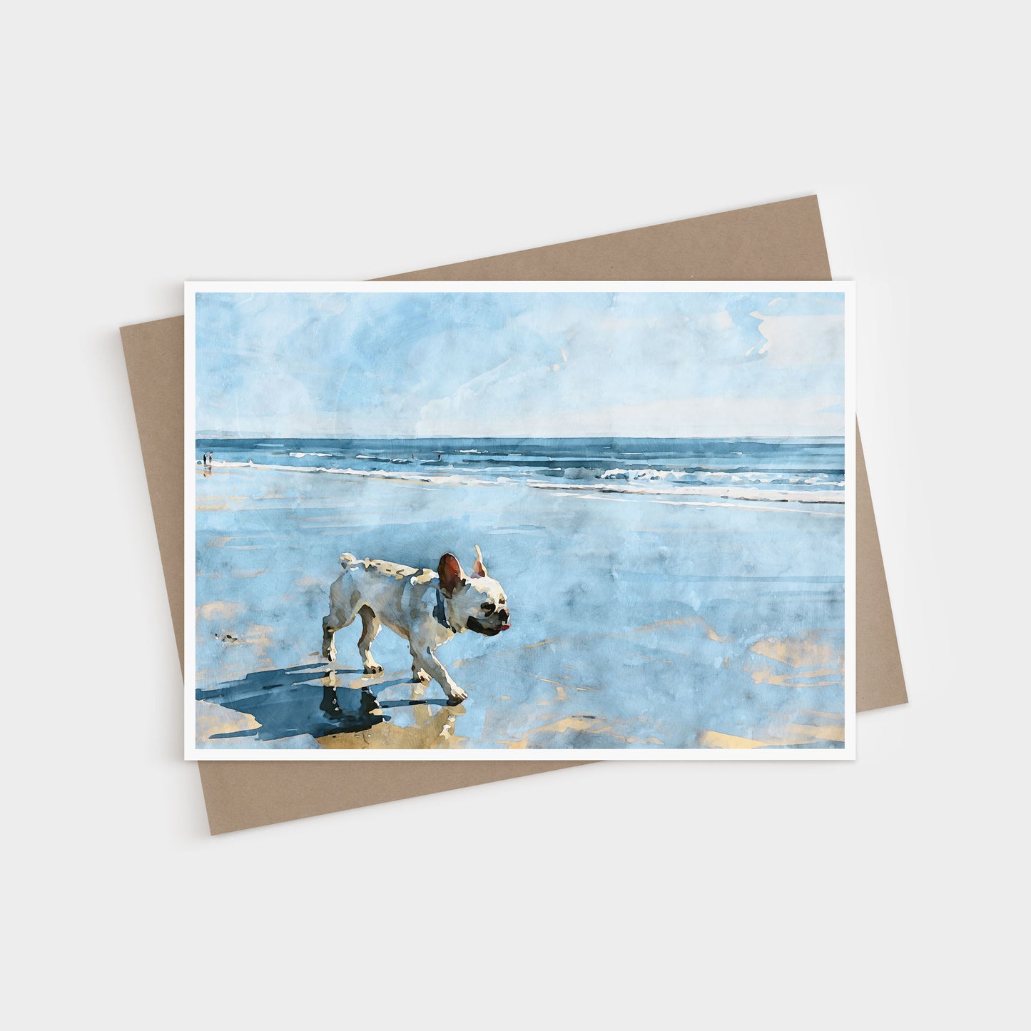 Cream French Bulldog beach note card displayed with a kraft envelope and soft blue coastal watercolor artwork.
