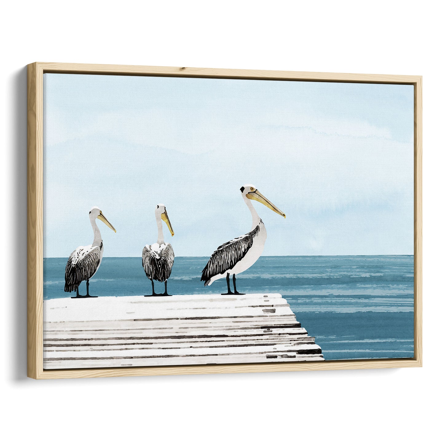 Natural wood framed canvas print featuring three pelicans standing on a weathered white dock above calm blue ocean water, under a soft, cloudy sky.