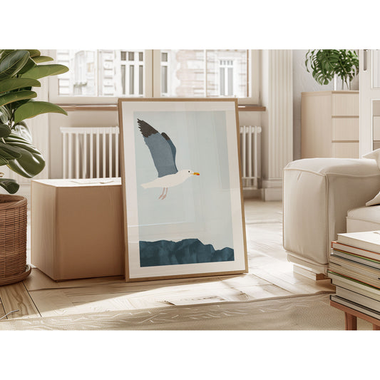 Framed minimalist illustration of a seagull in flight above a rocky surface, leaning against an ottoman in a modern living space with natural light.
