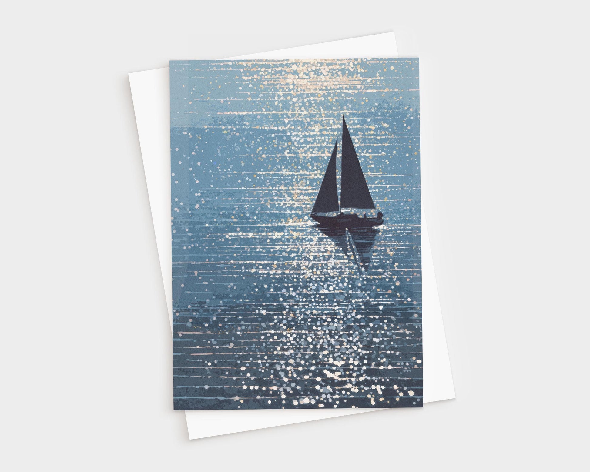 Greeting card featuring a silhouetted sailboat gliding across shimmering blue water, with sparkling sunlight scattered across the waves. The artwork has a dreamy, painterly style with rich navy and soft aqua tones. A white envelope is partially visible behind the card.