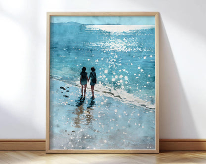 Framed art print featuring a watercolor-style painting of two women walking hand in hand along the shore, with sunlight sparkling on the waves and casting soft reflections on the wet sand. The scene is rendered in cool shades of blue and aqua, evoking a dreamy, peaceful beach atmosphere.