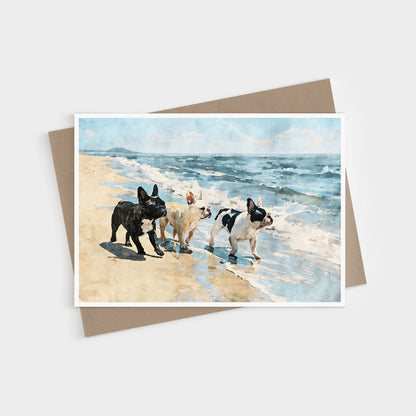 Three French Bulldogs beach note card displayed with a kraft envelope and blue tan coastal watercolor artwork.