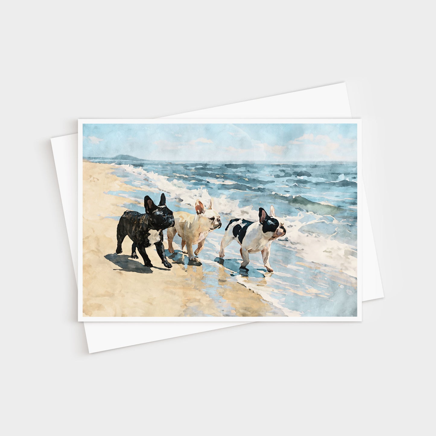 Three French Bulldogs beach note card shown with a white envelope and soft blue ocean scene.