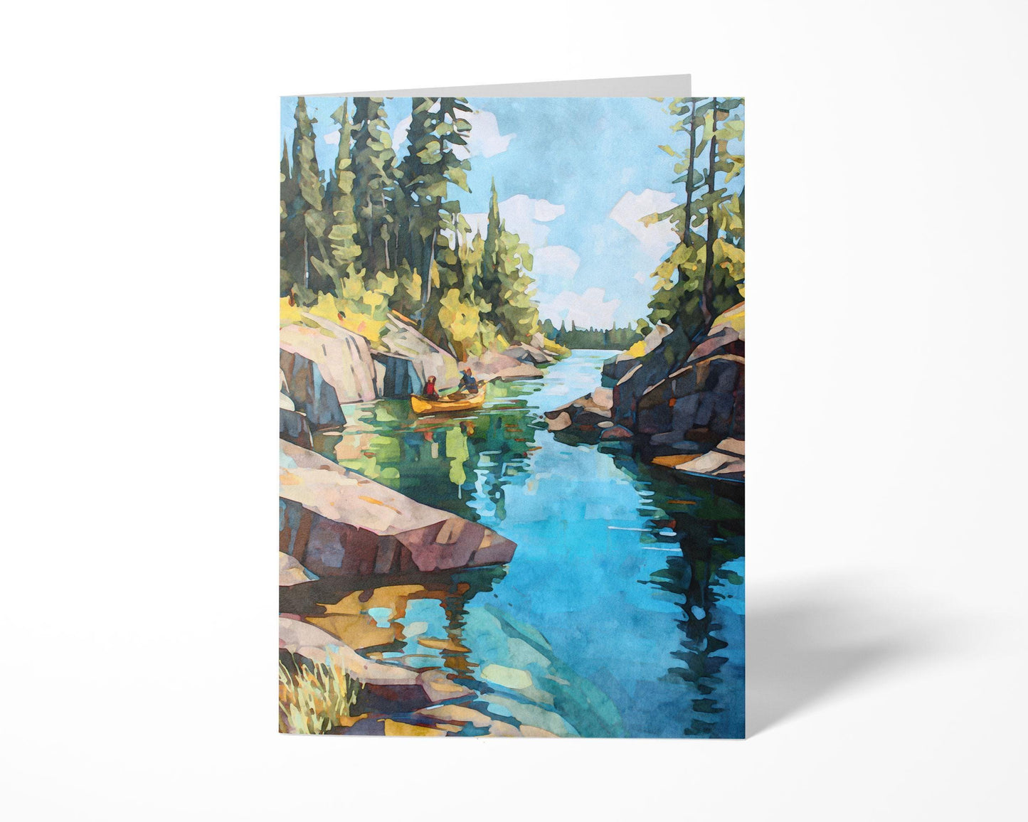 Folded greeting card featuring a watercolor painting of a golden canoe gliding through a turquoise lake, surrounded by pine trees and rocky cliffs under a bright blue sky with scattered clouds. Card displayed standing against a white background.