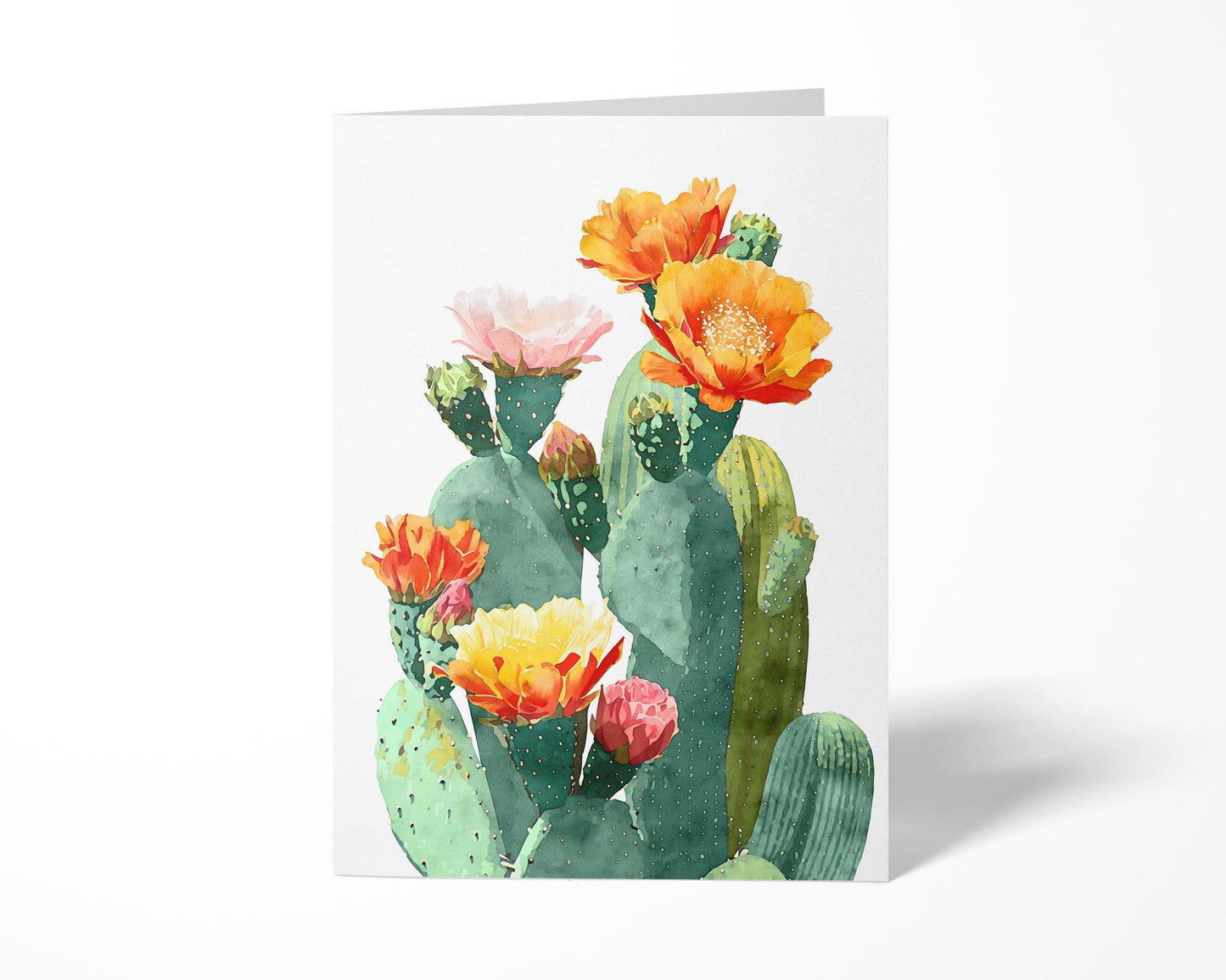 Greeting card standing upright with a watercolor illustration of green prickly pear cacti adorned with vibrant orange, yellow, pink, and red blossoms, set against a clean white background.