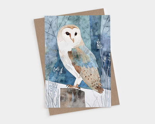 Watercolor-style illustration of a barn owl perched on a wooden post in a snowy, moonlit forest. The owl’s soft cream and brown feathers contrast with the cool blue and teal background of abstract winter trees and delicate plant silhouettes. The card is paired with a natural brown kraft envelope on a white background.
