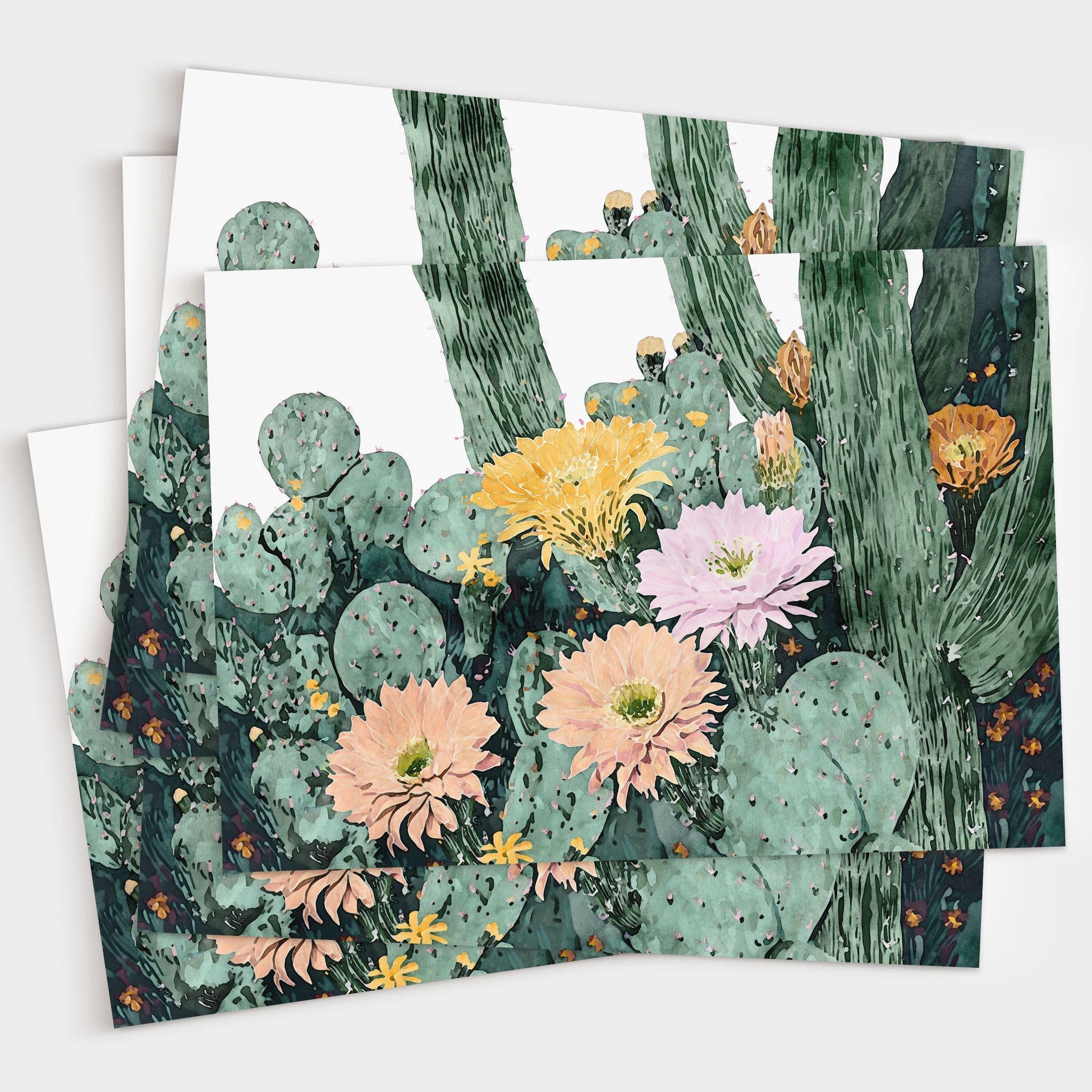 Set of greeting cards featuring a watercolor illustration of cacti with blooming flowers in peach, pink, yellow, and orange tones, layered to show multiple cards stacked together on a white background.