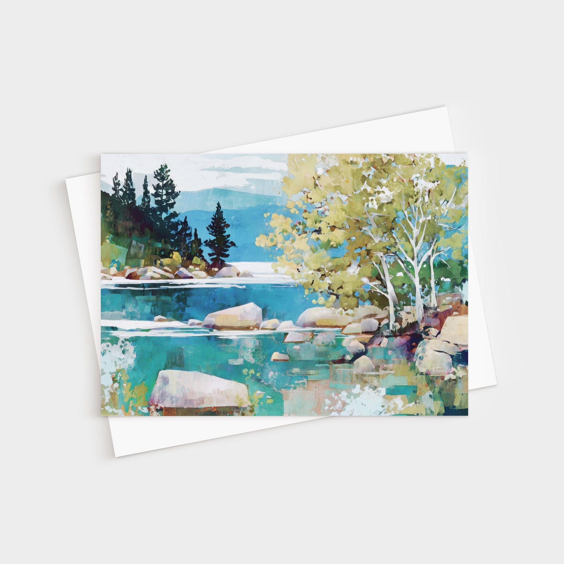 Greeting card featuring a modern impressionist landscape painting of a tranquil lake with turquoise water, smooth boulders, and shoreline trees. Birch trees with pale trunks and golden-green leaves stand in the foreground, while dark evergreens rise against distant mountains and a soft blue sky. Card is paired with a white envelope.