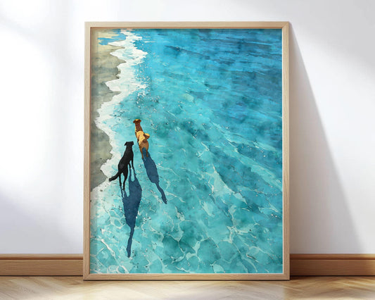 Framed art print of two dogs walking along the shore, one black and one golden, with long shadows cast into the clear turquoise surf. Rendered in a dreamy watercolor style, the piece captures a peaceful moment by the ocean with soft light and gentle waves.