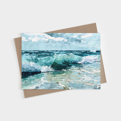 Watercolor greeting card featuring a seascape with turquoise waves crashing onto the shore under a partly cloudy blue sky, paired with a brown kraft envelope.