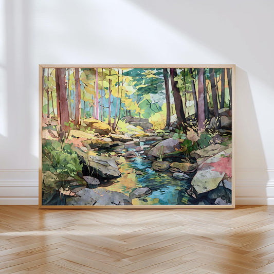 Framed watercolor-style art print of a forest scene with tall trees, large rocks, and a clear stream reflecting light, leaning against a white wall on a wooden floor.