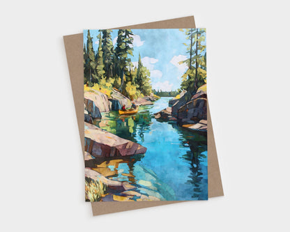 Watercolor greeting card depicting a narrow lake channel with tall pines and rocky cliffs. A golden canoe floats on the calm turquoise water, which reflects the sky and trees. The scene captures a peaceful wilderness atmosphere.