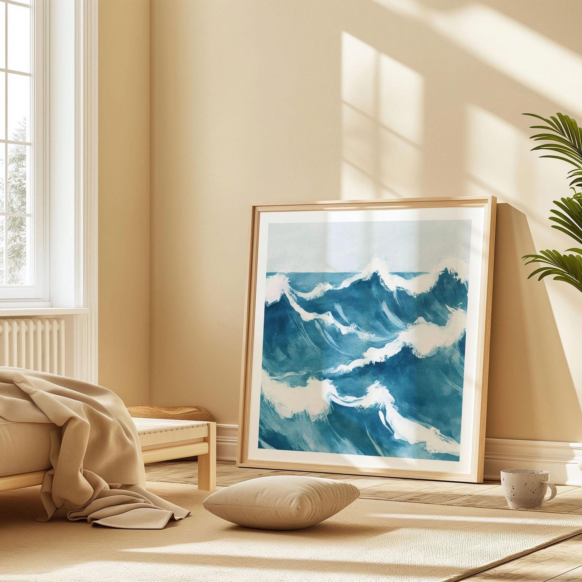 Framed ocean wave painting propped against the wall in a serene, sunlit bedroom. The artwork showcases dynamic blue waves with frothy white crests, adding a calming coastal touch to the minimalist space filled with soft neutrals, warm wood tones, and cozy textures.