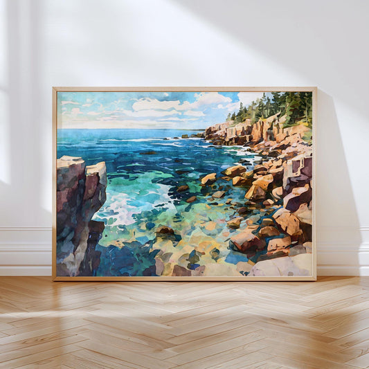 Framed artwork of a watercolor-style coastal scene resting on a hardwood floor against a white wall. The painting depicts rocky cliffs with pine trees overlooking a vibrant turquoise and deep blue ocean under a partly cloudy sky.