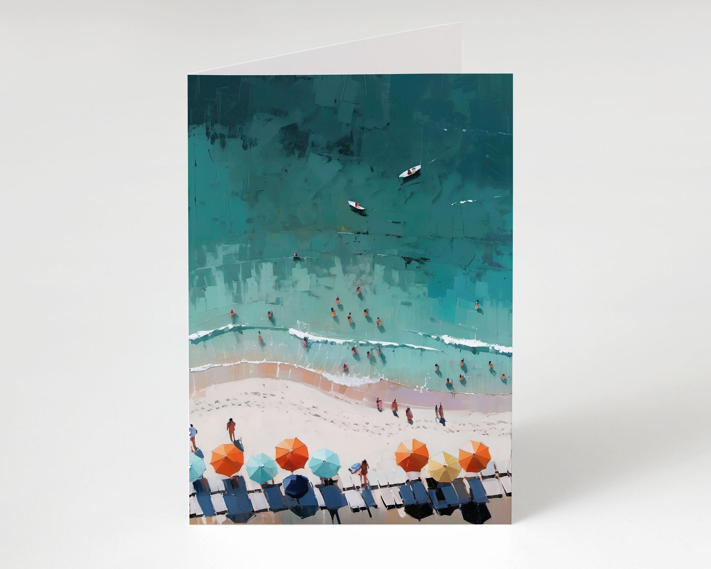 Greeting card standing upright with a painterly aerial beach scene featuring turquoise water, swimmers, small boats, and rows of colorful umbrellas and lounge chairs along the shoreline.
