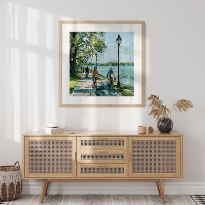Square framed Minneapolis Chain of Lakes cyclist artwork shown in a styled room.