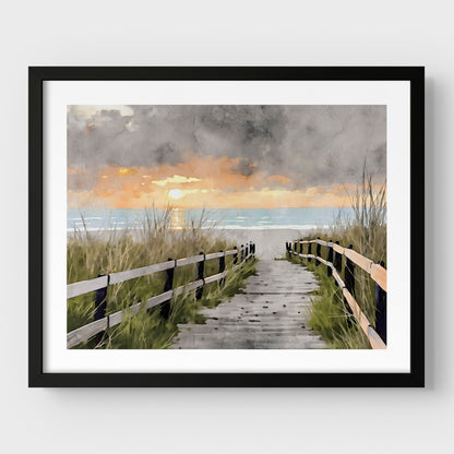 Black framed artwork with a border, featuring a watercolor-style depiction of a wooden boardwalk flanked by grassy dunes, leading to the ocean at sunset with a dramatic cloudy sky.