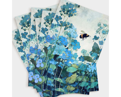 Set of watercolor-style note cards featuring a bumblebee hovering among blue forget-me-not flowers, with layered teal and green foliage. Multiple prints are fanned out, highlighting the botanical design in soft, cool blue tones.
