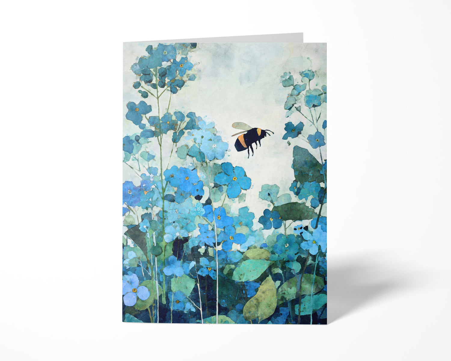 Folded greeting card featuring a watercolor-style bumblebee hovering among soft blue forget-me-not flowers with layered teal and green foliage, set against a clean, light background.