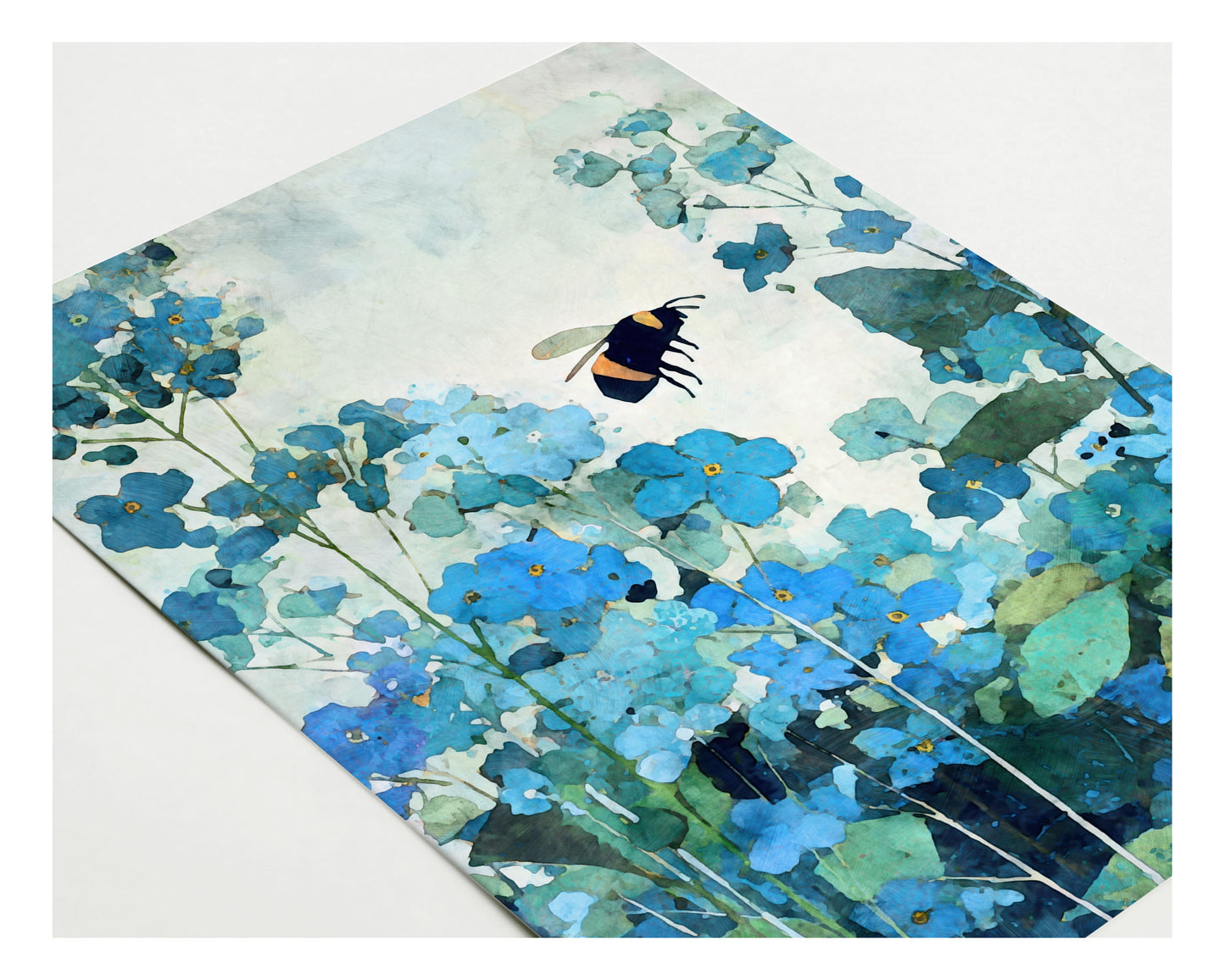 Angled view of a watercolor-style note card featuring a bumblebee hovering among blue forget-me-not flowers, with layered teal and green foliage against a pale, airy background.