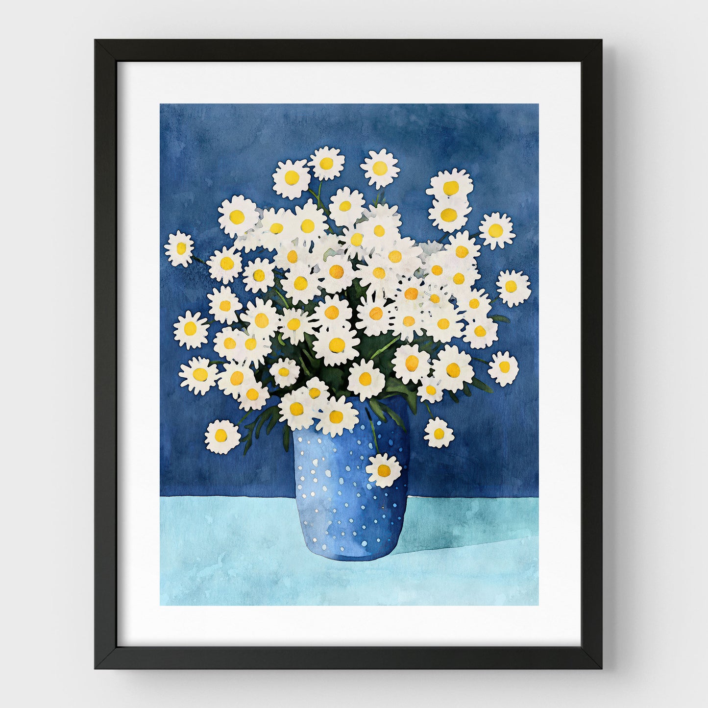 Artwork with a black frame and white border, featuring a watercolor-style depiction of white chamomile flowers with yellow centers in a blue polka-dotted vase, set against a deep blue background and light blue surface.