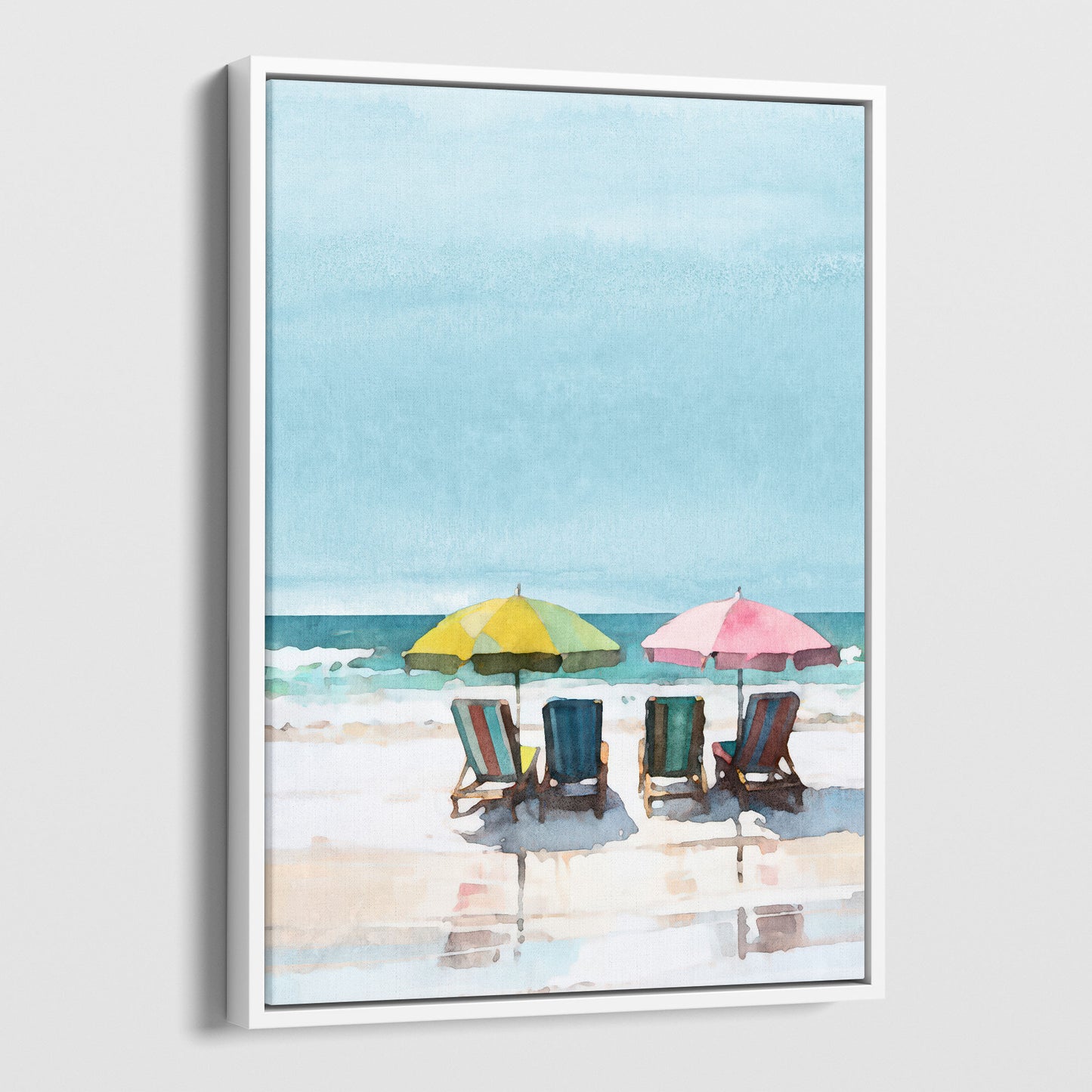 Watercolor painting depicting a serene beach scene with four empty lounge chairs under a yellow and a pink umbrella, set against a calm sea and blue sky. Artwork printed on gallery wrap canvas in white floater frame.