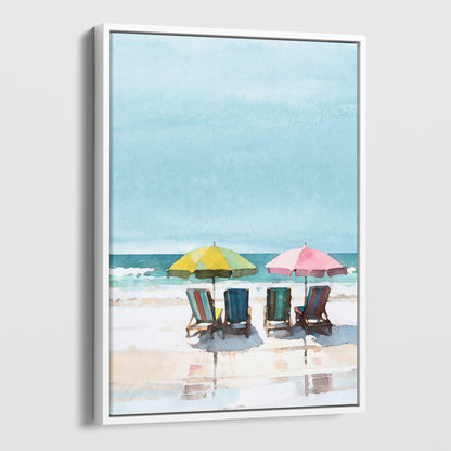 Watercolor painting depicting a serene beach scene with four empty lounge chairs under a yellow and a pink umbrella, set against a calm sea and blue sky. Artwork printed on gallery wrap canvas in white floater frame.