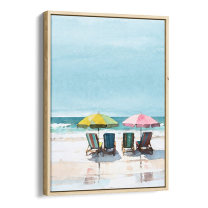 Watercolor painting depicting a serene beach scene with four empty lounge chairs under a yellow and a pink umbrella, set against a calm sea and blue sky. Artwork printed on gallery wrap canvas in natural floater frame.