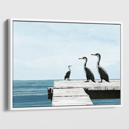 White framed canvas print featuring a minimalist seascape with three cormorants perched on a white dock above calm blue ocean water, under a pale sky.