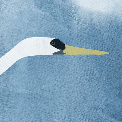 Close-up of a greeting card featuring a white heron with raised wings flying across a textured blue background, with soft, cloud-like shapes surrounding the bird.