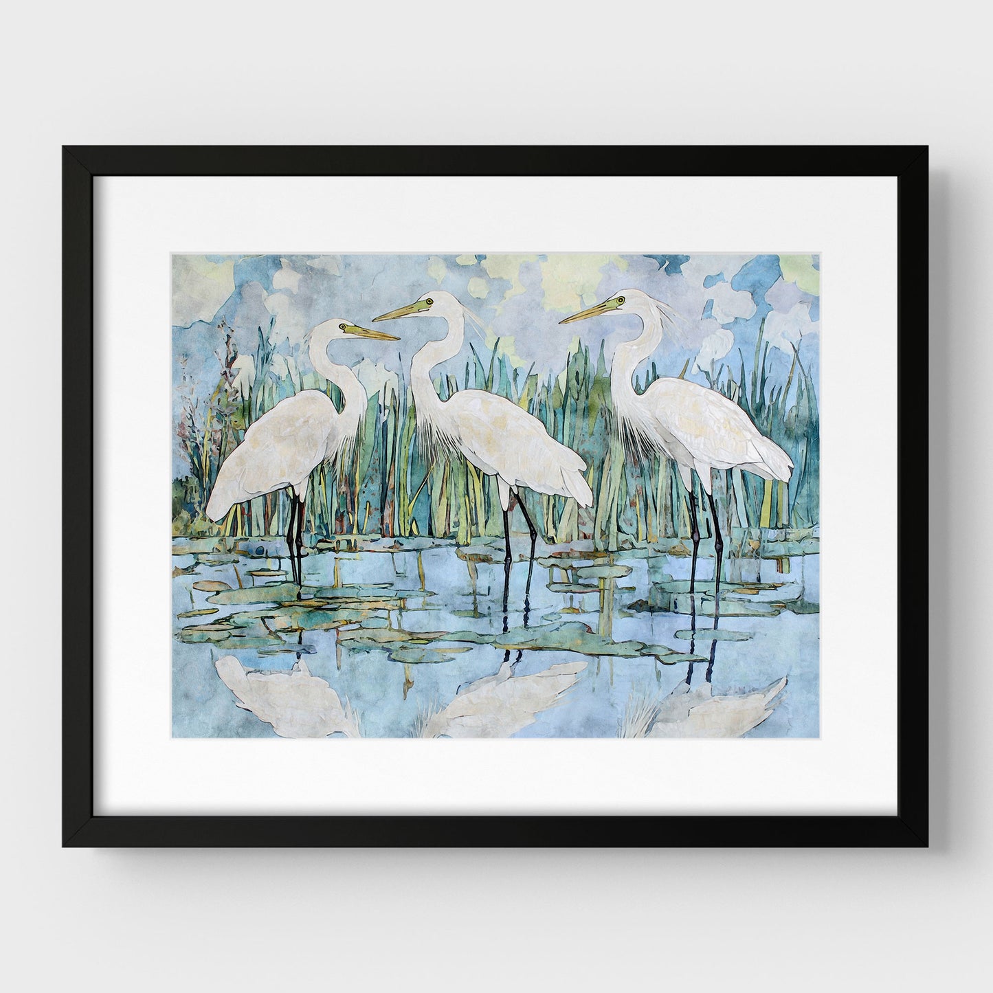 Framed artwork of three white birds in a natural setting with water and reeds.