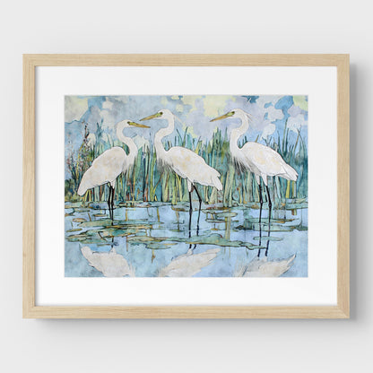 Framed artwork of three white birds in a natural setting with a light wooden frame.