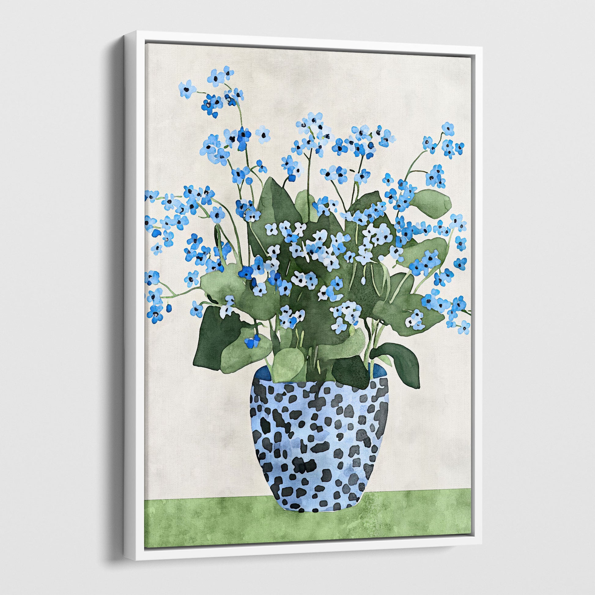 Canvas print with a white frame, featuring a watercolor-style depiction of blue forget-me-not flowers with green leaves, arranged in a patterned blue vase, set against a soft neutral background with a green surface.