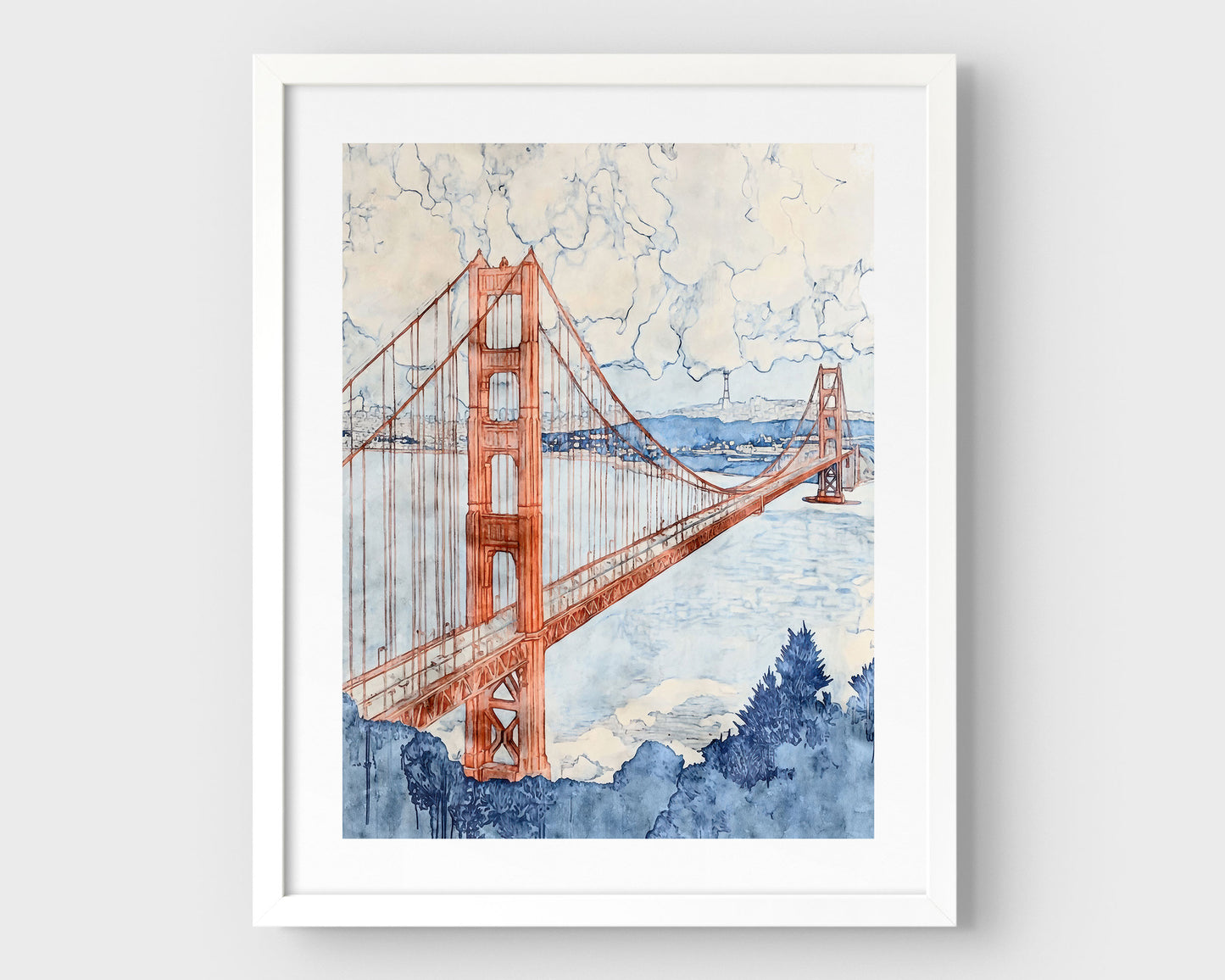 Watercolor-style painting of the Golden Gate Bridge, viewed at an angle with one tower in the foreground and the second in the distance. The bridge is rendered in soft rust red tones, stretching across a pale blue bay with hills and buildings in the background, and a cloudy sky above. Framed in white with a white border.