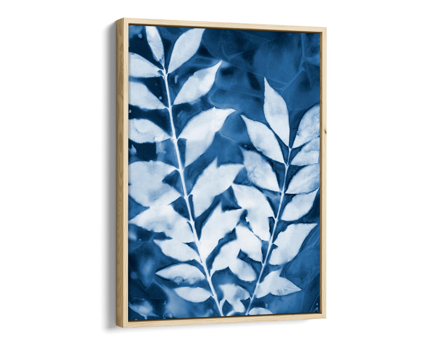 Natural wood framed cyanotype print of two leafy branches in deep blue and white, highlighting organic textures and intricate vein details.