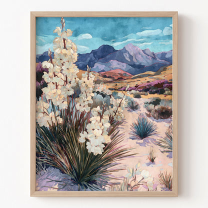 Framed artwork of a desert landscape with white flowers and mountains.