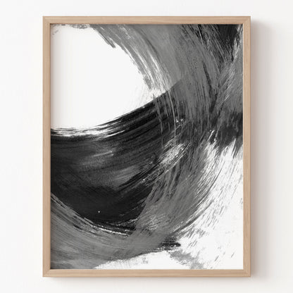 Framed abstract art print with black and white brush strokes on a white wall.