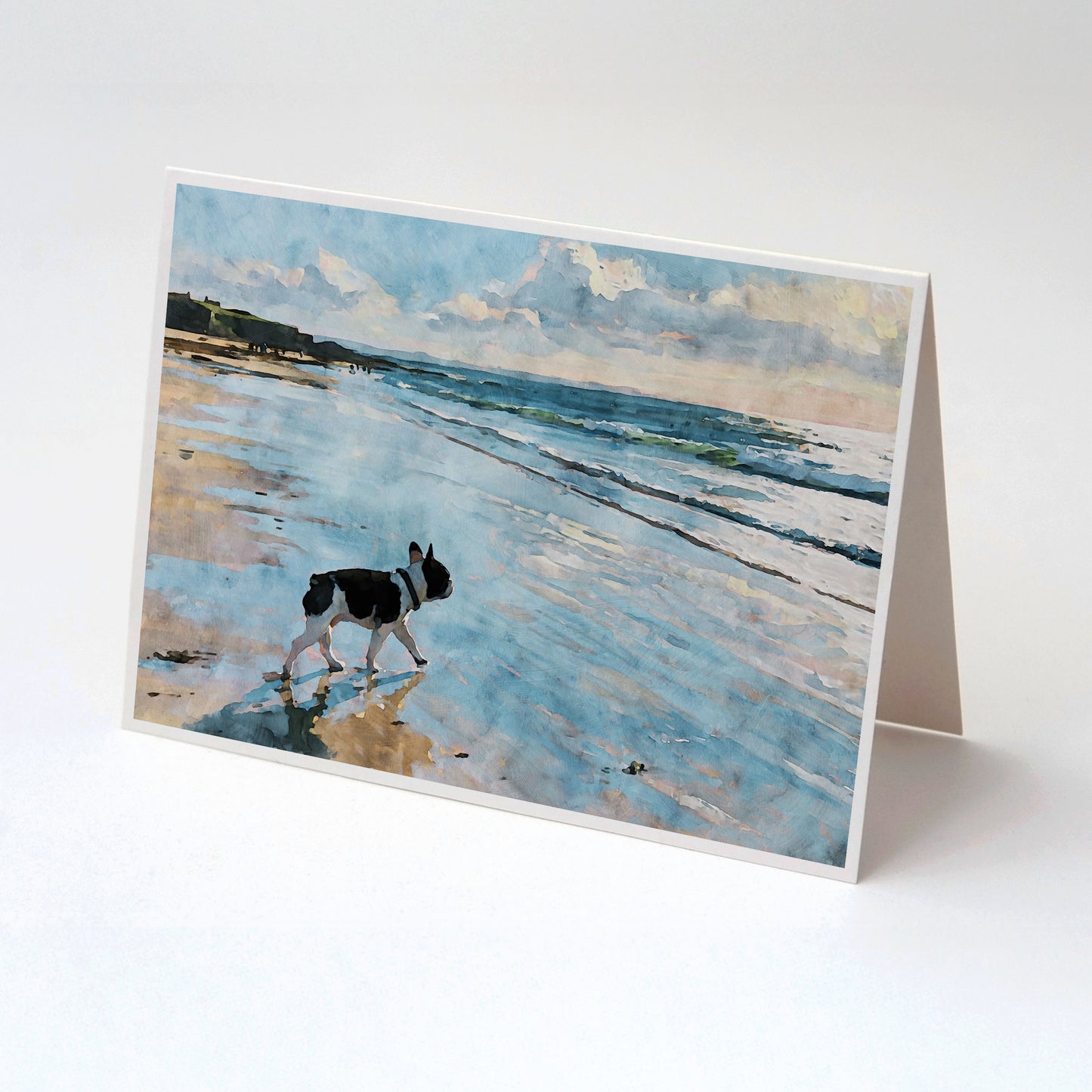 Tented folded note card with a pied French Bulldog beach watercolor and soft blue shoreline background.