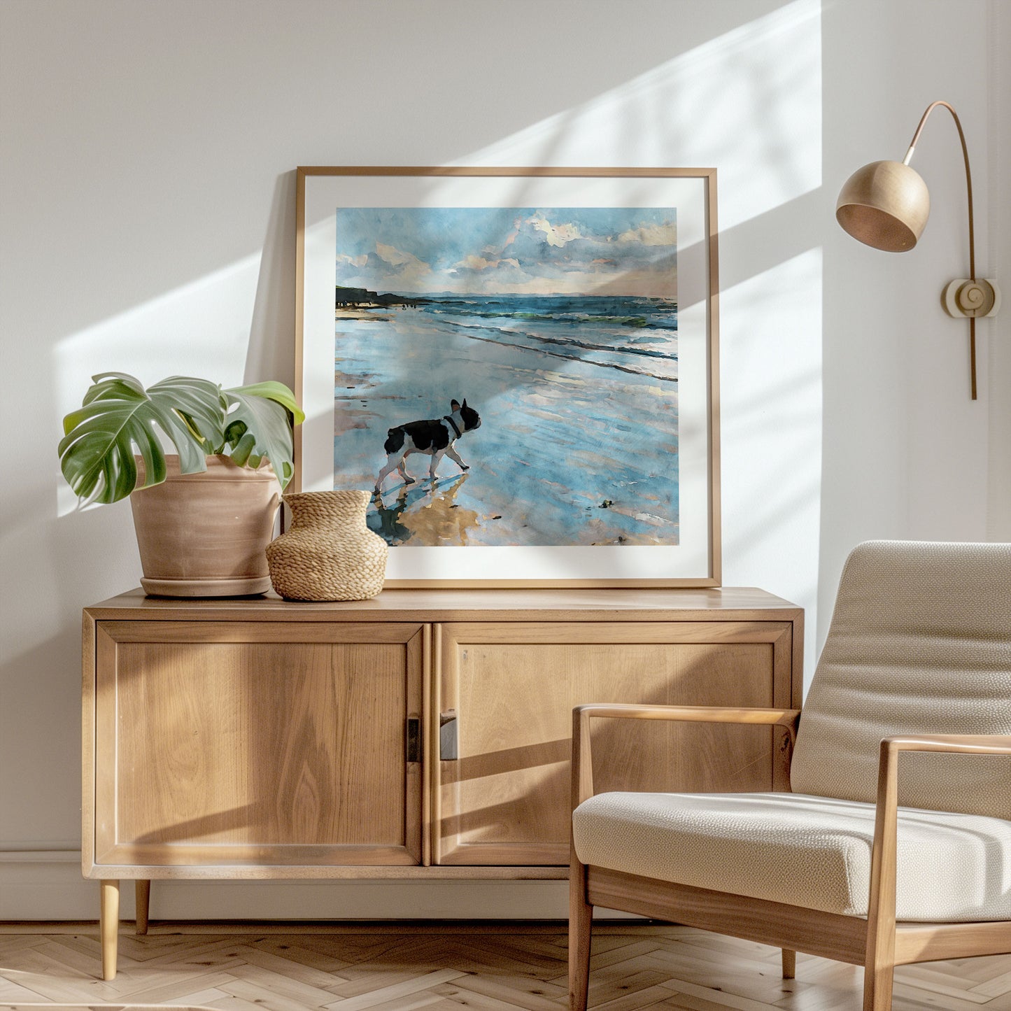 Square framed watercolor print of a pied French Bulldog on a beach shown in a styled interior.