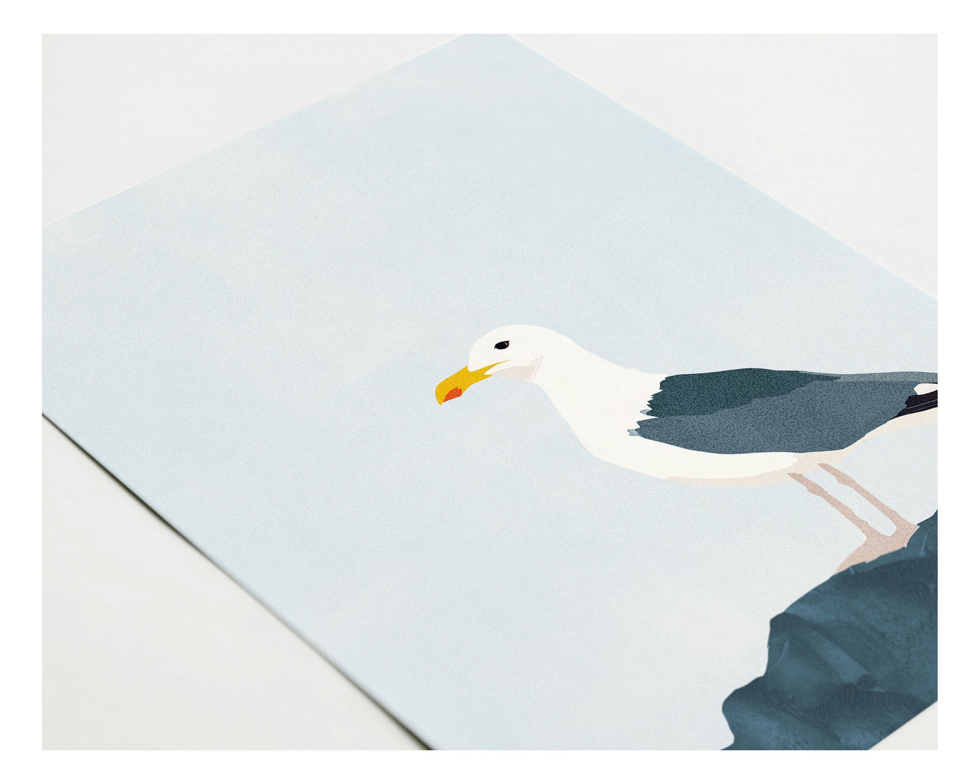 May include: A white seagull with a yellow beak perched on a dark blue rock. The seagull is facing left and has its wings spread out. The background is a light blue sky.