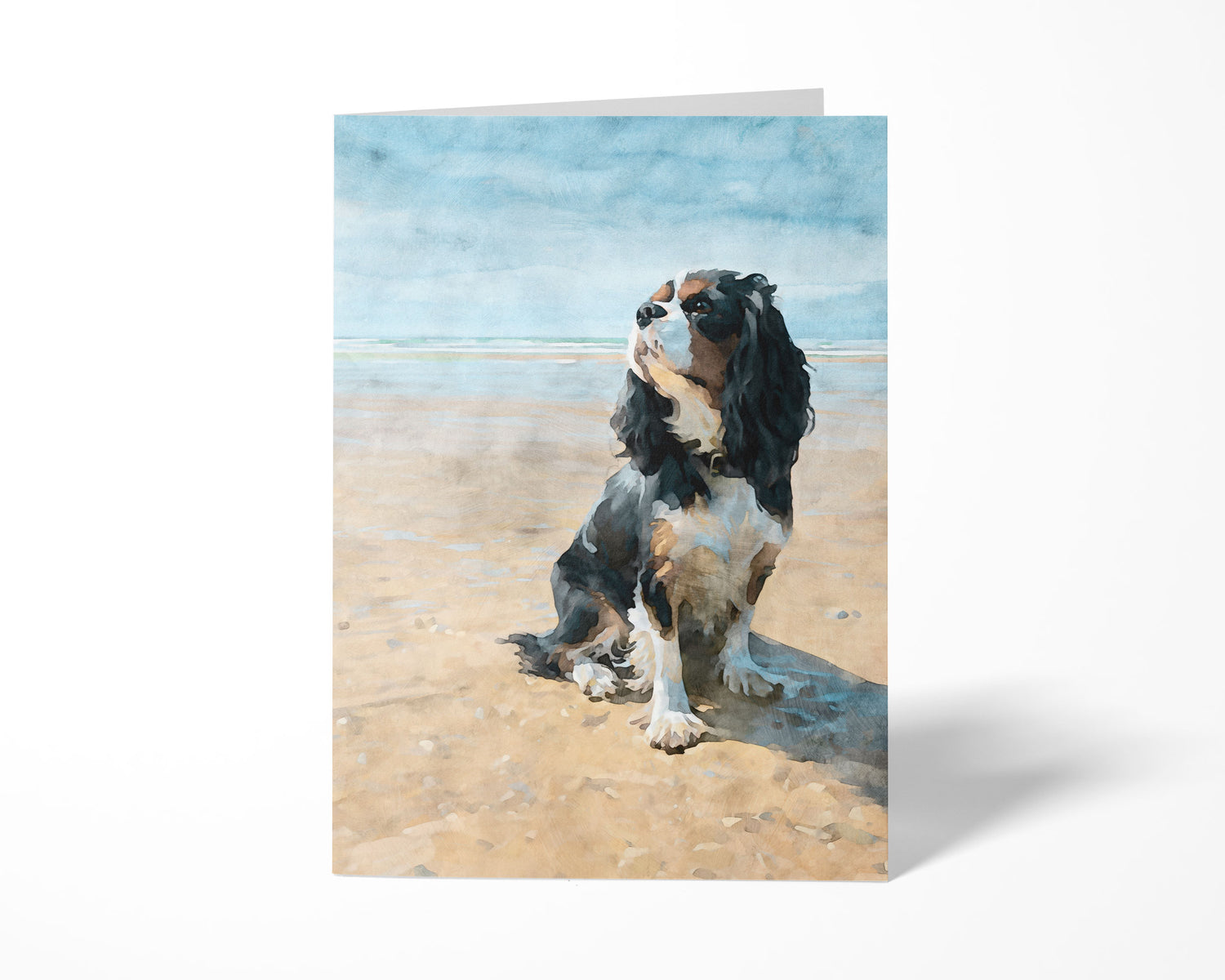 Greeting card with a tricolor Cavalier King Charles spaniel on a beach design