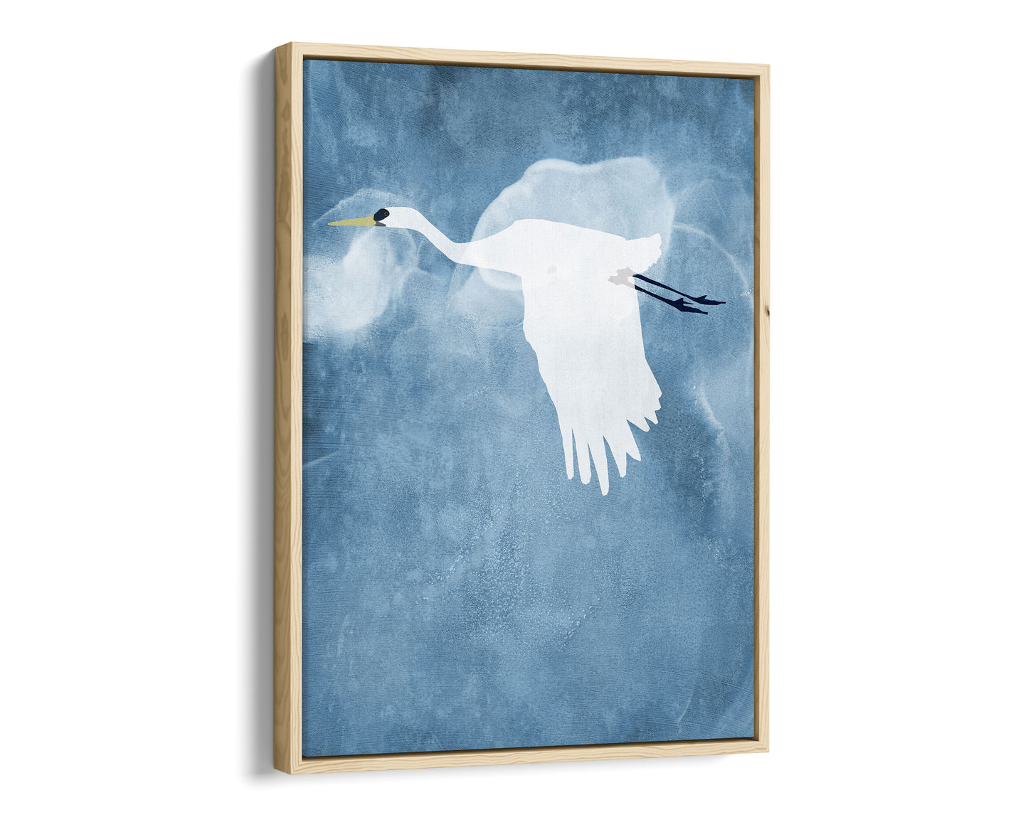 Natural wood framed canvas print of a white heron in flight with wings lowered, set against a textured blue background with soft cloud-like swirls.