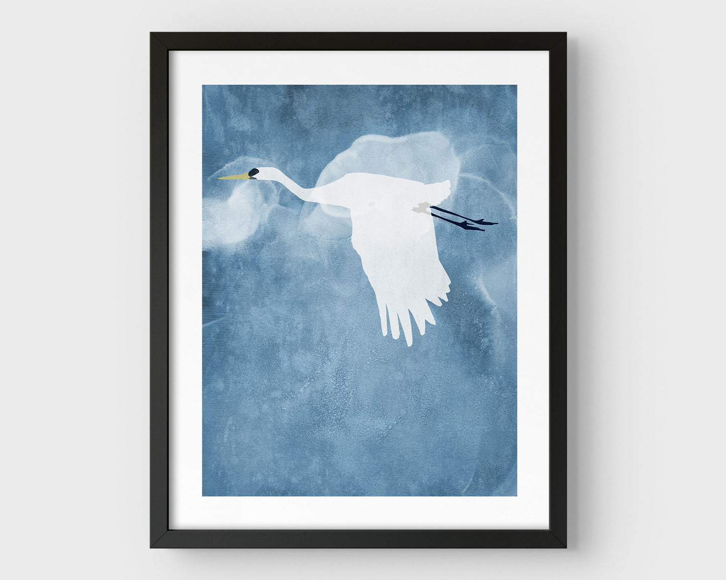 Minimalist black framed print of a white heron flying with wings lowered against a textured blue sky with soft, cloud-like forms in the background.