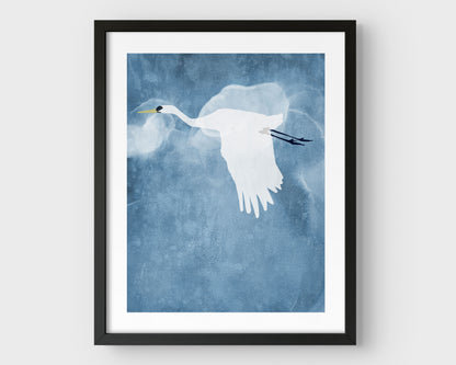 Minimalist black framed print of a white heron flying with wings lowered against a textured blue sky with soft, cloud-like forms in the background.