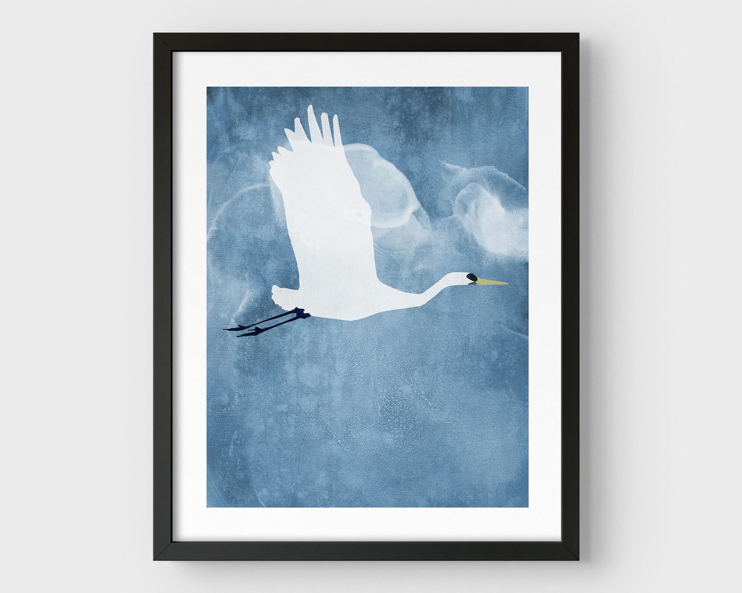 Black framed vertical print of a white heron in flight with wings raised, set against a textured blue background with cloud-like forms.