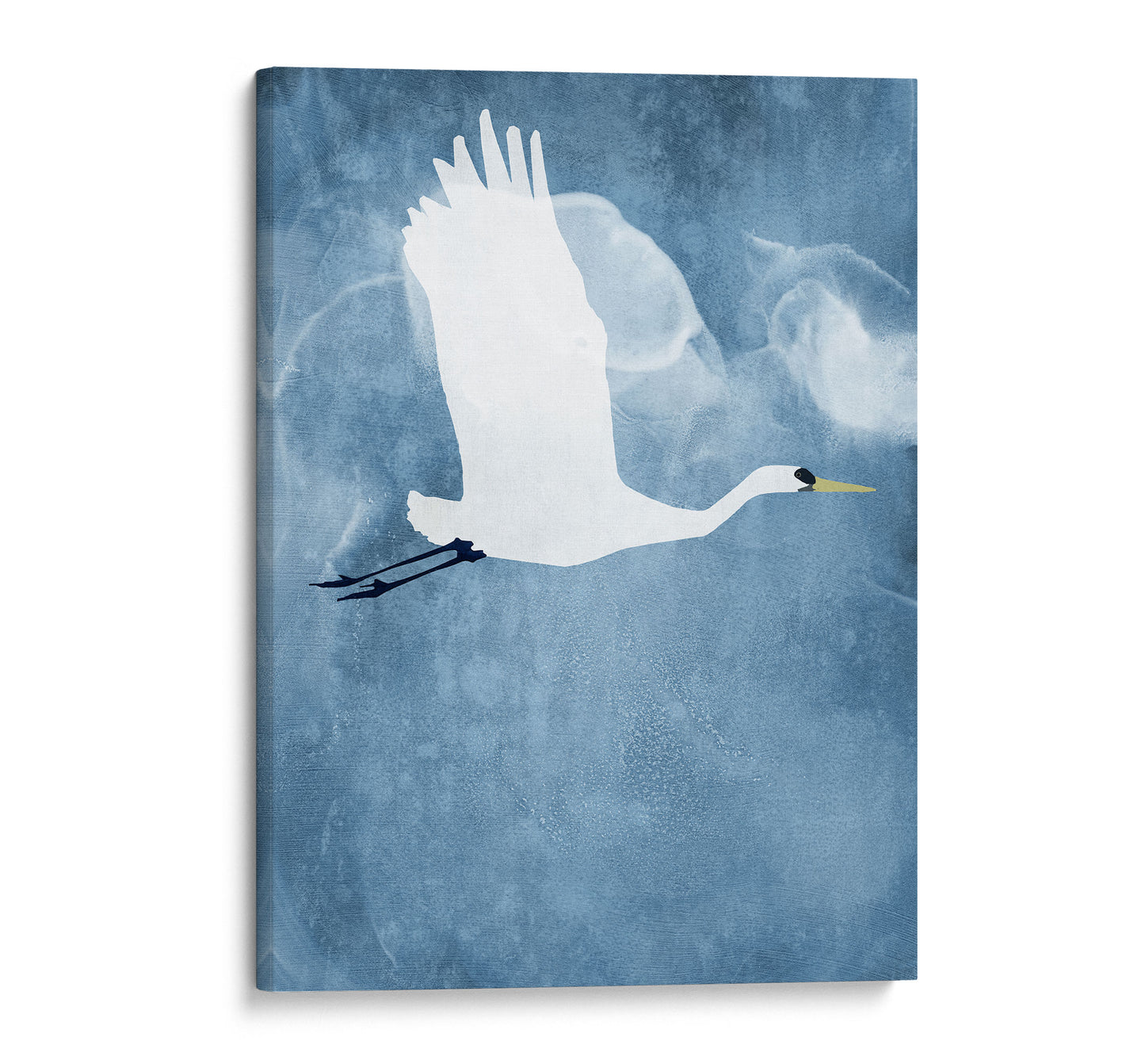 Gallery-wrapped canvas print of a white heron flying with wings raised, set against a textured blue background with soft, cloud-like swirls.