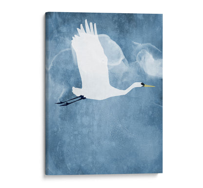 Gallery-wrapped canvas print of a white heron flying with wings raised, set against a textured blue background with soft, cloud-like swirls.