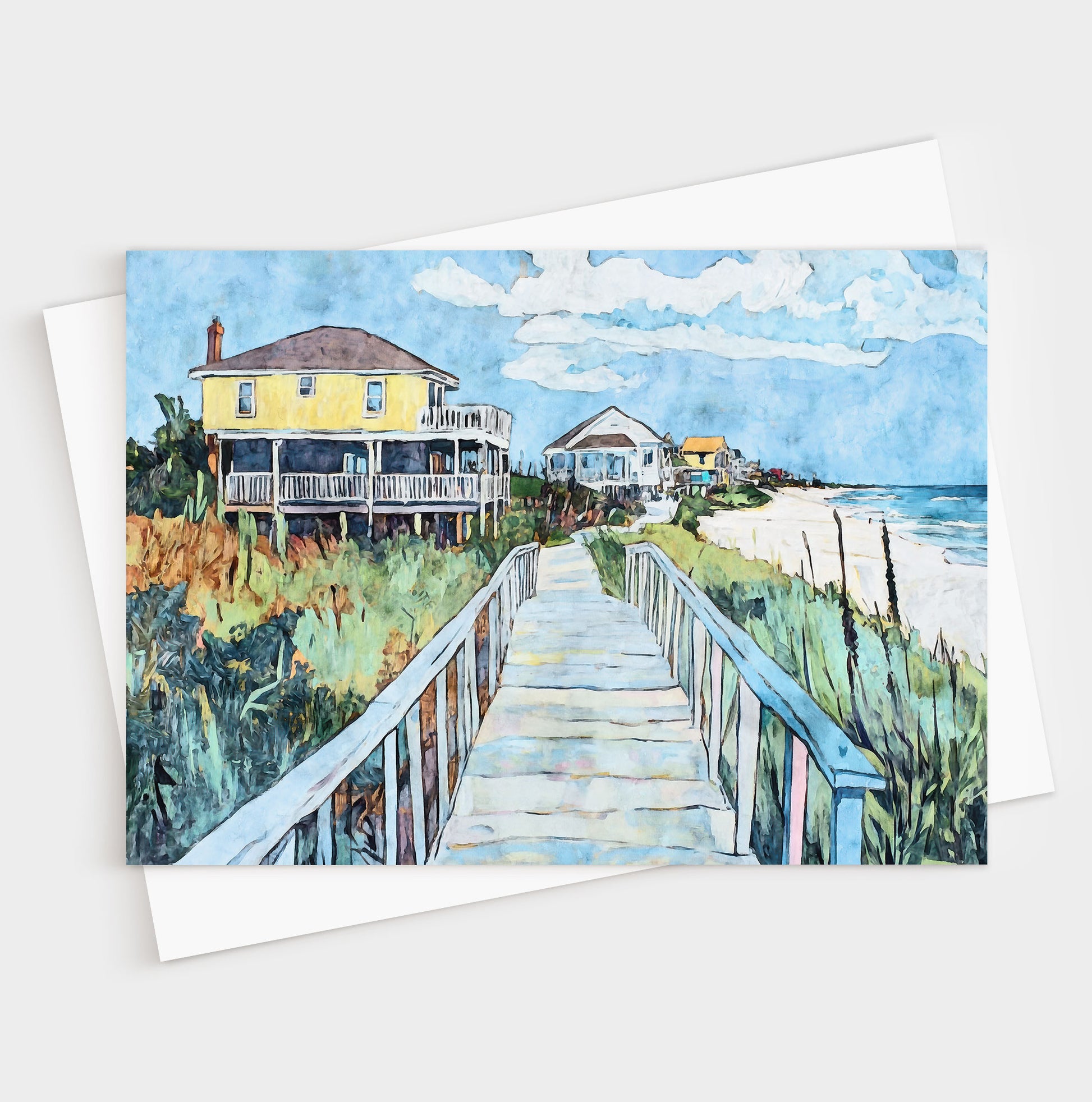 Folded greeting card featuring a vibrant watercolor-style illustration of a coastal boardwalk leading past colorful beach houses toward the ocean. A bright yellow house stands out in the foreground, framed by sea oats, greenery, and soft blue skies, capturing the relaxed charm of a seaside neighborhood.
